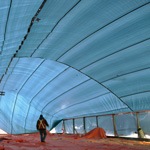 Tarp over pre-fabricated building construction site